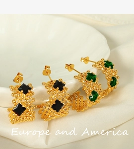 Détail de boucles d'oreilles C en plaqué or 18K avec zircons noirs et vert émeraude