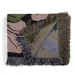 Detailed macro view of woven jacquard texture and colorful tassel edges on a camping blanket