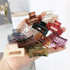 Detailed close-up of colorful square hollow resin hair claws held in a hand