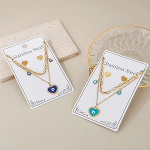 Detail of gold-plated stainless steel double-layered necklace and heart evil eye studs