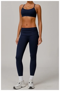 Detail of navy blue high-waist yoga leggings and strappy sports bra on a model