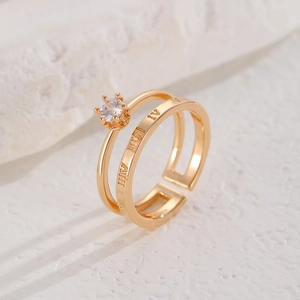 Detail of gold double-layer open ring with six-prong zircon and Roman numerals