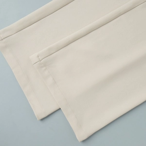 Detail of high-density woven fabric hem with precise stitching on beige trousers