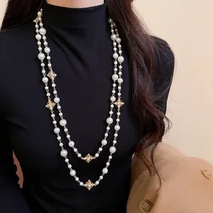 Elegant multi-layer pearl necklace with gold cross charms and sparkling crystal accents