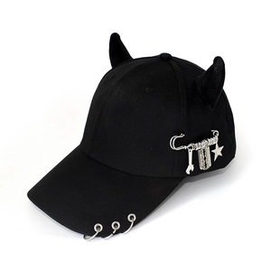 Detail of black punk baseball cap featuring silver metal rings and heavy pendant charms