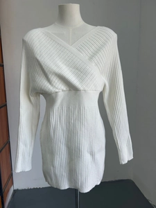 Detail of the cross V-neckline and knitted texture on this white slim fit dress