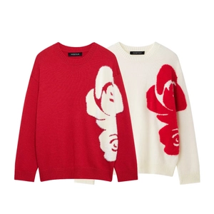 Detail of red and cream knit sweaters featuring large contrast floral rose patterns
