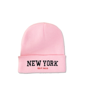 Close-up of pink knit beanie with black NEW YORK embroidery and red EST. 1625 text