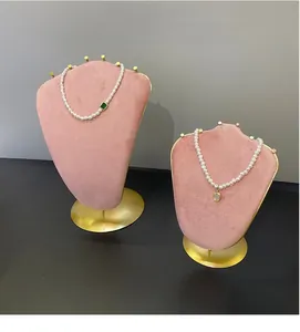 Detailed display of pearl necklaces with green emerald pendant on a pink velvet jewelry stand