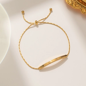 Elegant gold adjustable bracelet featuring a curved bar engraved with Lover Dream text
