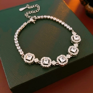 Détail macro du bracelet en zircon argenté sur une boîte à bijoux en cuir vert