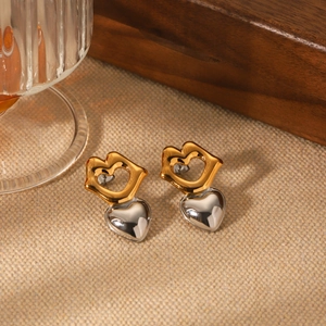 Two-tone lip shaped gold studs with silver 3D heart charms on beige fabric