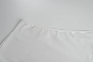 Dettaglio del tessuto a maglia bianco con bordo rifinito e cuciture di alta qualità