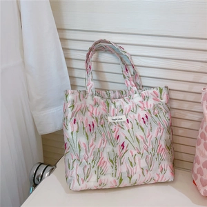 Close-up of pink tulip embroidery on textured fabric with Simple Wish brand label