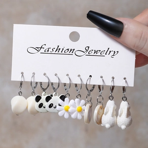 Close-up of 6 pairs of resin drop earrings including panda and daisy motifs on card
