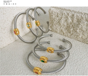 Macro view of six cable twist bangles with colorful marquise-cut stones and golden details