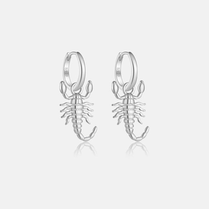 Close-up of S925 sterling silver scorpion pendant hoop earrings on a reflective surface