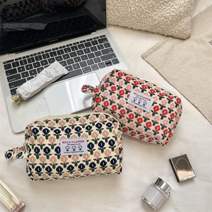 Detail of floral corduroy cosmetic bags featuring vintage wild flower patterns and zippers