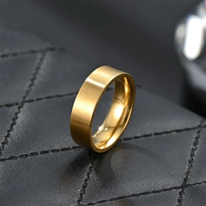 Detail view of 6mm matte gold titanium steel flat ring on black leather background
