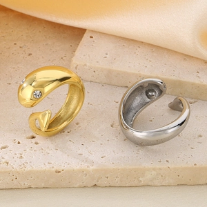 Macro detail of 18k gold and silver dolphin rings with inlaid crystal eyes on stone