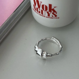 Detail view of a 925 sterling silver croissant ring on a desk with a modern cup