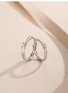 Macro shot of S925 sterling silver couple rings with X-shaped design and zircon inlay