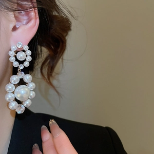 Gros plan de boucles d'oreilles perles avec strass brillants et style vintage