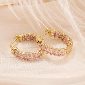 Golden S925 earrings with pink rectangular zircons on elegant beige silk background