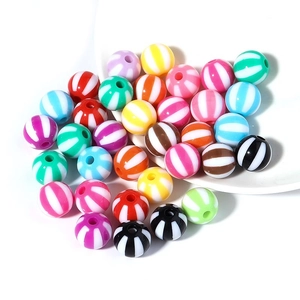 Colorful striped acrylic beads assortment for DIY jewelry making in a white dish