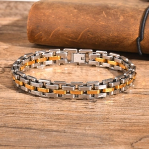 Macro view of two-tone gold and silver stainless steel watchband chain bracelet on wood