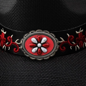 Macro view of ethnic style leather band with a vintage metal buckle on a woven cowboy hat