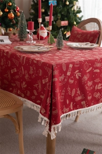 Detailed view of red Christmas tablecloth with tassels and white holiday jacquard patterns