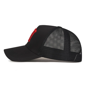 Black trucker hat with red embroidery and breathable mesh panels, side profile view