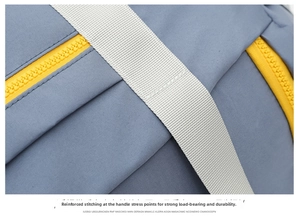 Detail shot of travel bag fabric, reinforced white strap and yellow zipper for durability.