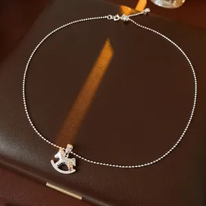 Collier élégant avec pendentif cheval à bascule argenté sur fond en cuir et lumière chaude