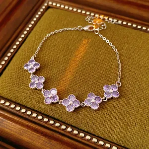 Elegant silver flower bracelet with purple zircon crystals on a green velvet box