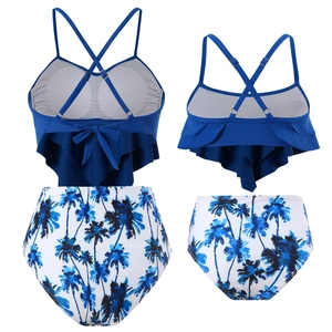 Close-up of blue ruffled tankini top and high-waisted coconut tree print bikini bottom