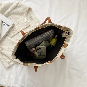 Large capacity woven tote bag with brown straps and vertical stripes in a lifestyle setting