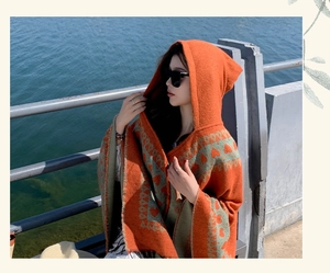 Ethnic style hooded orange shawl poncho featuring a bohemian heart knit pattern outdoors