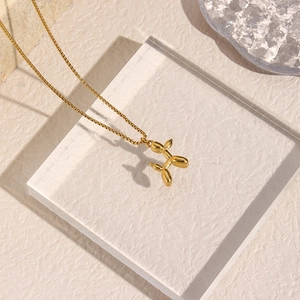 Detail shot of a 18K gold plated stainless steel balloon dog pendant on a slim chain