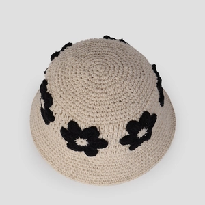 Vue de dessus détaillée du chapeau cloche au crochet beige avec fleurs noires en 3D