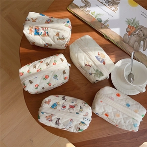 Top view of quilted animal print makeup bags on wood table with soft natural lighting