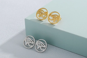 Detail of Eye of Horus hollow earrings in gold and silver finish on geometric stands