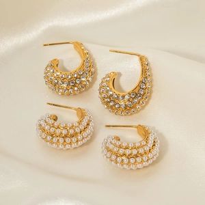 Chic C-shaped conch earrings set with shimmering rhinestones and faux pearls on beige silk