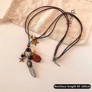 Detail of vintage feather pendant with turquoise bead and star on 80-100cm leather cord