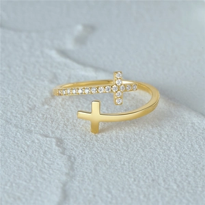 Macro detail of gold double cross ring with sparkling pavé zircons on textured stone