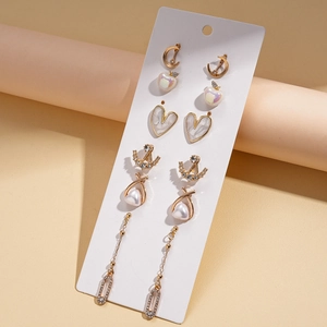 Detail of 6-pair gold earring set featuring heart textures, pearls, and crystals on card