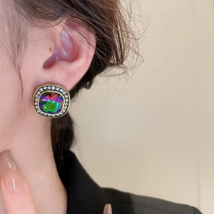 Gros plan de boucles d'oreilles vintage carrées aux reflets irisés et cristaux