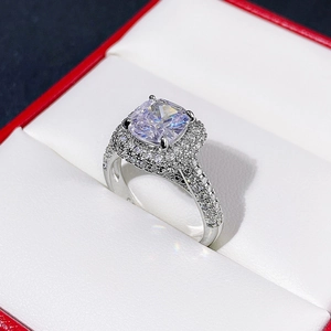 Macro shot of cushion-cut double halo ring with pave-set diamonds in a red jewelry box