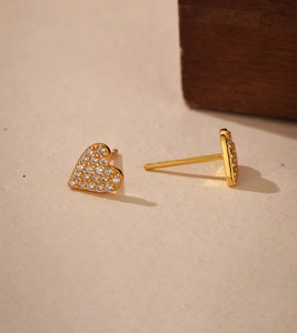 Macro shot of gold heart stud earrings micro-paved with clear cubic zirconia stones